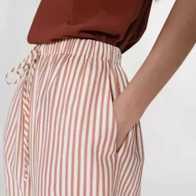 Calças com riscas verticais castanhas e brancas com cordão na cintura e t-shirt castanha