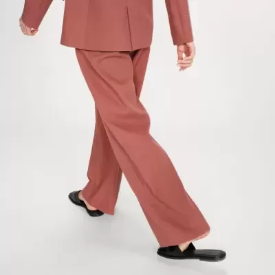 Calças terracota largas com blazer a condizer e sapatos pretos.