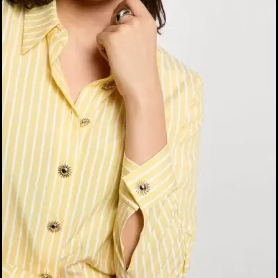 Camisa feminina amarela às riscas com botões decorativos em forma de sol