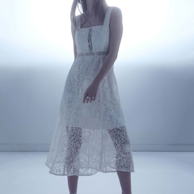 Mulher com vestido branco de renda e sapatos de salto prateados