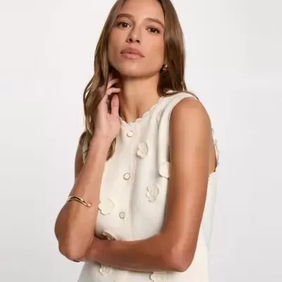 Camisa de alças branca com flores em relevo e botões frontais.