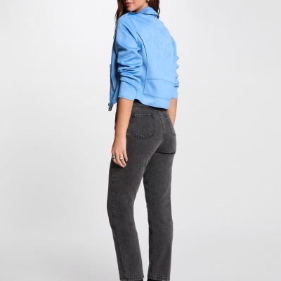 Mulher de costas com calças de ganga pretas e camisola azul clara