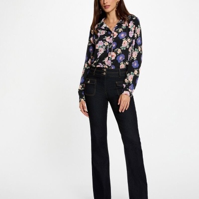 Mulher vestindo camisa floral preta e calças escuras em fundo branco