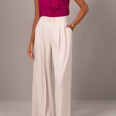 Top rosa fúcsia e calças largas bege em fundo cinza liso