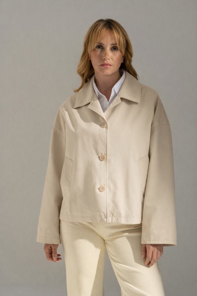 Mulher com casaco bege claro de botões e calças claras