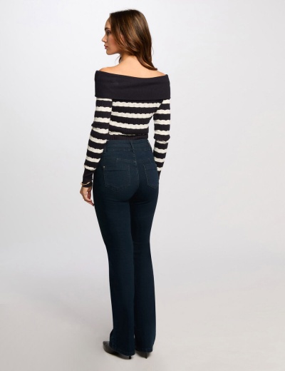 Mulher de costas com camisola às riscas e calças de ganga azul escuro