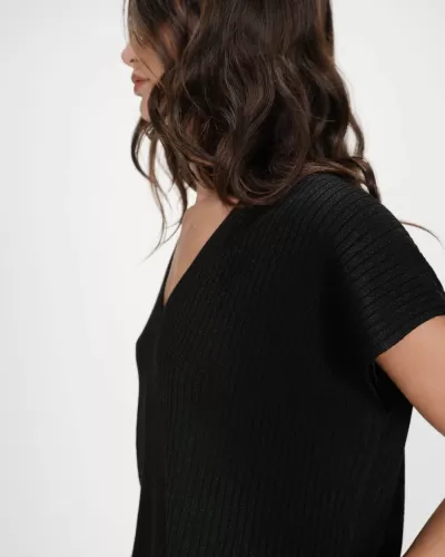 Mulher com camisola preta de malha canelada e decote em V