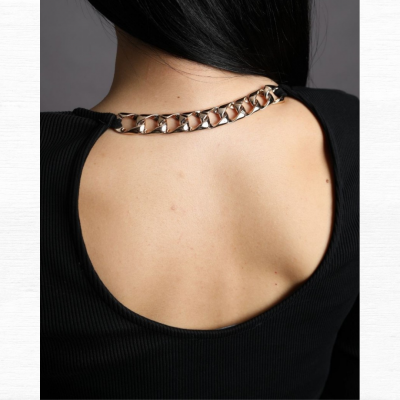 Peça de vestuário preta com decote redondo e corrente metálica prateada no pescoço