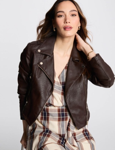 Mulher a usar casaco de pele castanho escuro e vestido às riscas sob fundo branco