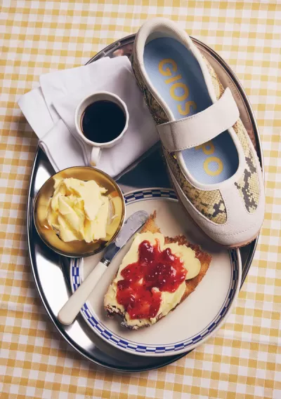 Sapatilha Gioseppo com padrão pele de cobra sobre tabuleiro com pequeno-almoço