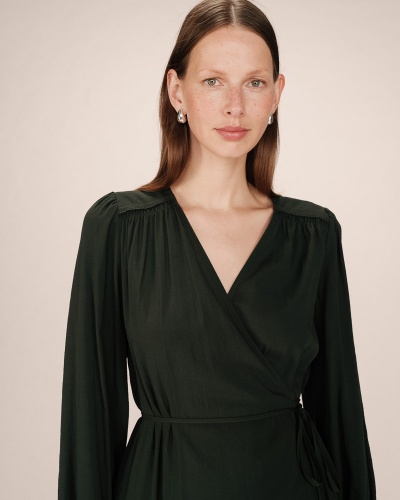 Mulher com vestido preto de manga comprida e decote em V