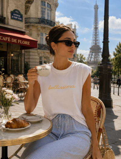 Mulher com t-shirt branca bellissima e calças azuis numa esplanada em Paris com chávena Café de Flore.