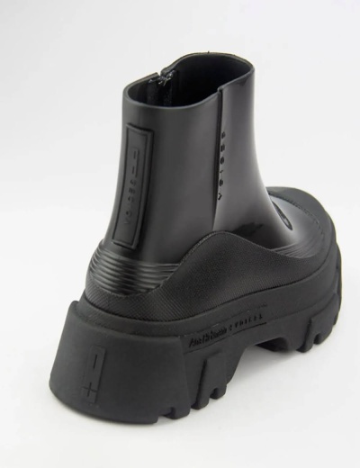 Botim preto de sola grossa e corpo em couro e tecido, vista traseira