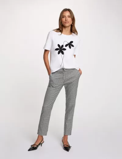 Conjunto feminino com t-shirt branca estampada e calças xadrez em preto e branco