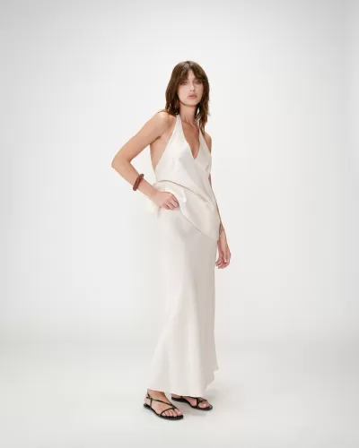 Mulher a usar vestido longo creme acetinado e sandálias pretas