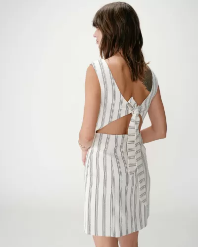 Vestido curto branco com riscas pretas e laço nas costas visto de trás