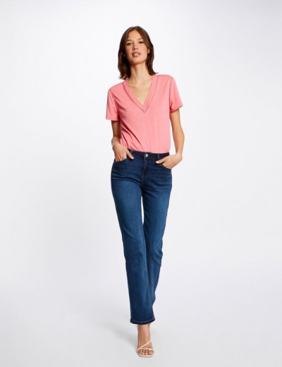 Mulher com t-shirt cor-de-rosa e calças de ganga azul escuro