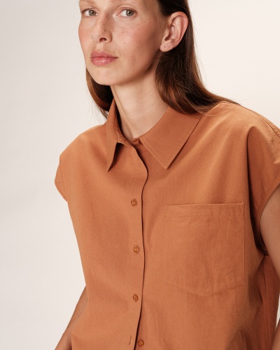 Camisa castanha de algodão com bolso e botões ao centro, gola tradicional, mangas curtas