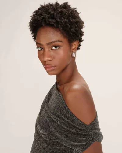 Mulher com vestido cinzento com ombro descoberto e brincos prateados