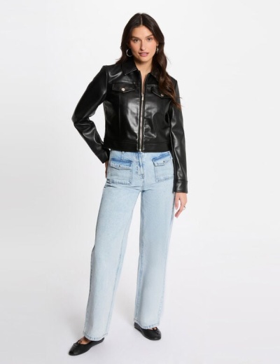 Mulher vestindo casaco preto de pele sintética e calças de ganga azuis claras.