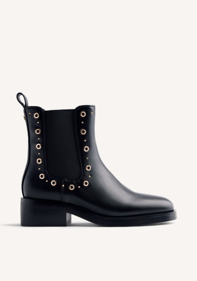 Botim preto em pele com elástico e ilhós dourados.