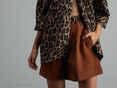 Calções castanhos com camisa de padrão animal print em modelo