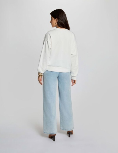 Mulher de costas com sweatshirt branca e calças de ganga azul claro