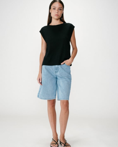 Mulher com t-shirt preta e calções de ganga azul claro.