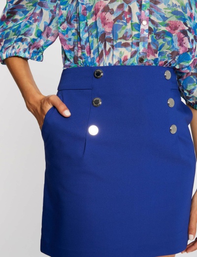Saia azul royal com botões prateados e blusa floral colorida