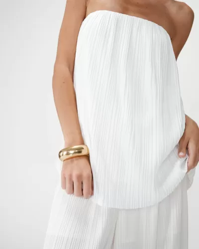 Vestido branco plissado e pulseira dourada no braço