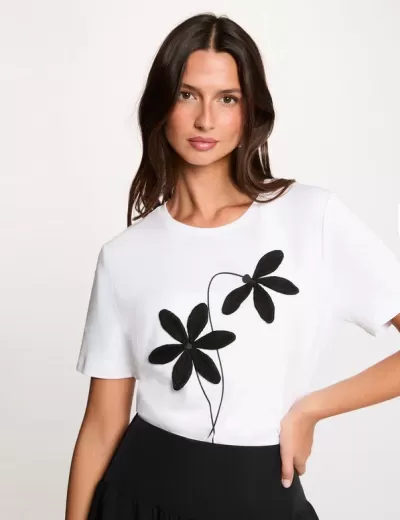 T-shirt branca com flores pretas aplicadas e saia preta