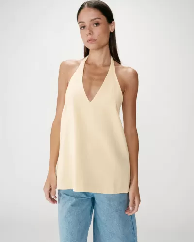 Top amarelo claro sem mangas com decote em V e calças jeans azuis claras