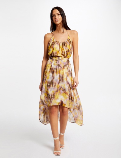 Vestido feminino amarelo e roxo com padrão abstrato e sandálias brancas