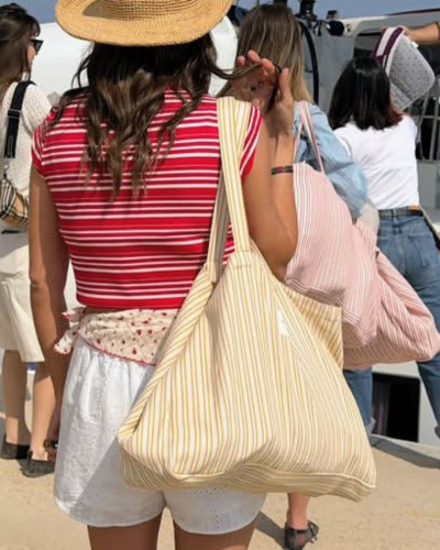 Mulheres com bolsas grandes às riscas em ambiente exterior