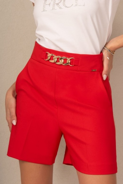 Calções vermelhos com cinto dourado e t-shirt branca com texto em strass