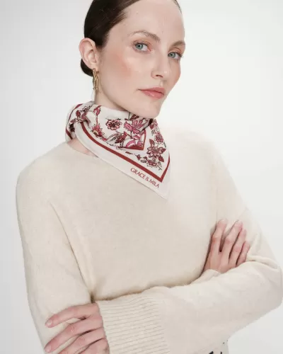 Mulher com lenço floral branco e camisola creme de malha