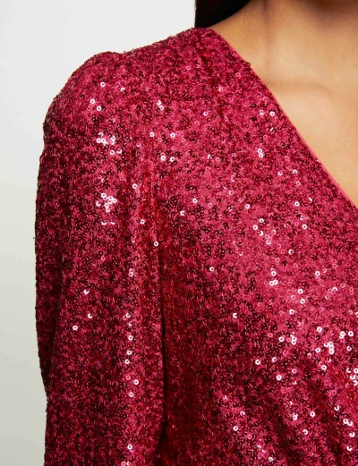 Roupa vermelha com lantejoulas brilhantes e decote em V