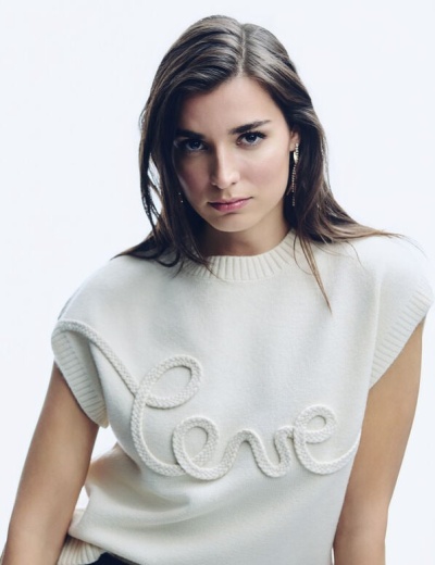 Mulher com camisola branca de malha com palavra love em relevo.