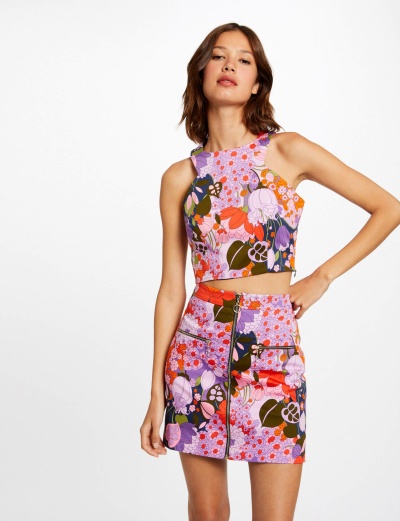 Conjunto feminino top cropped e saia curta com padrão floral colorido e fecho de correr frontal na saia.
