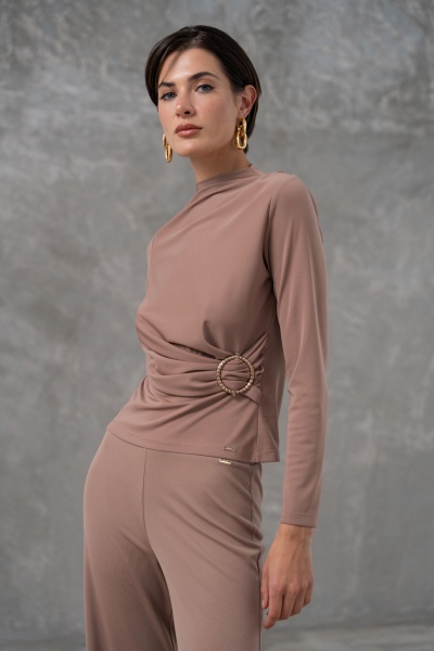 Conjunto feminino bege com blusa de manga comprida e calças, detalhe circular na cintura, fundo cinzento