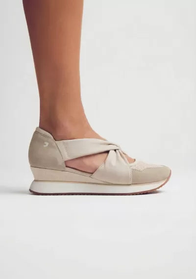 Ténis feminino bege com detalhe de nó e sola branca.