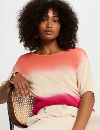 Camisola degradé coral a rosa com mangas curtas num ambiente minimalista
