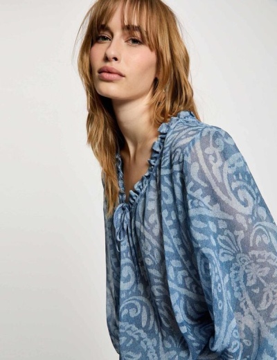 Blusa azul feminina com padrão floral e abstrato, gola frufru e laço no decote