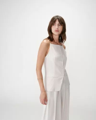 Mulher com conjunto branco composto por top e calças largas