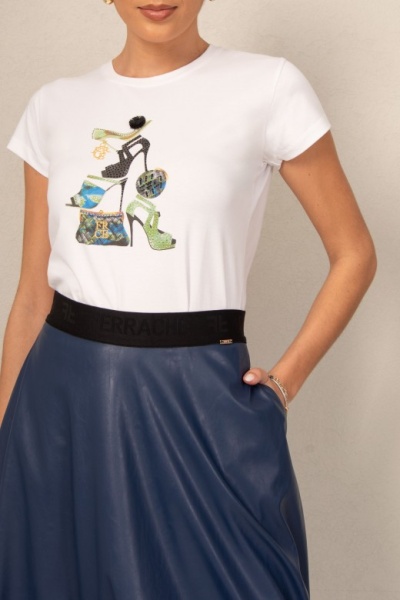 T-shirt branca com estampado colorido de sapatos e uma mala, saia azul escura e cinto preto