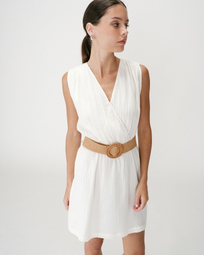 Vestido branco com cinto castanho em mulher jovem