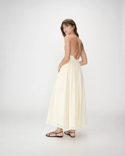 Vestido longo amarelo claro com padrão e alças cruzadas nas costas.