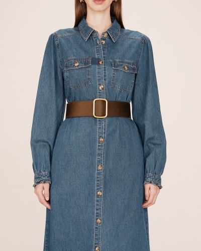 Vestido de ganga azul com cinto castanho em fundo neutro