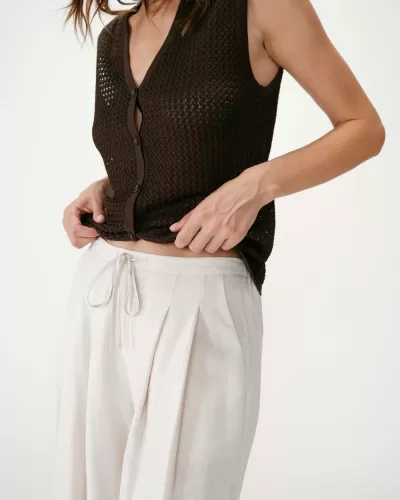 Top de malha castanho com botões e calças largas bege