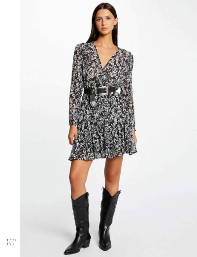 Mulher a usar vestido curto florido preto e branco com cinto preto e botas pretas